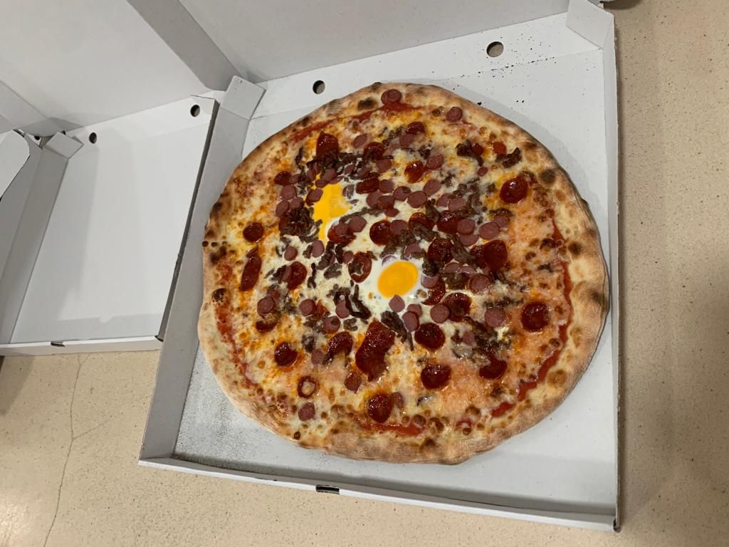 Pizza con chorizo, frankfurt, carne picada y huevo